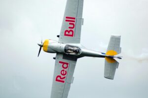 A light aircraft with the red bull logo on the wings.